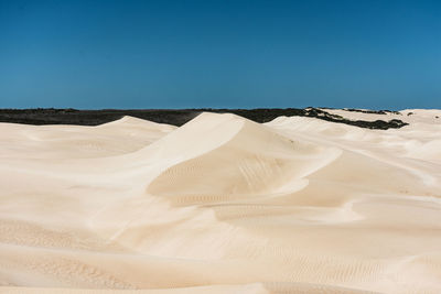 Sand dune in desert against clear blue sky