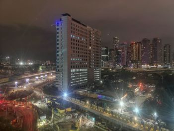 High angle view of illuminated buildings against sky at night