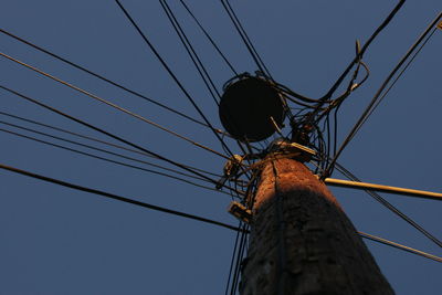Low angle view of electricity pylon against sky