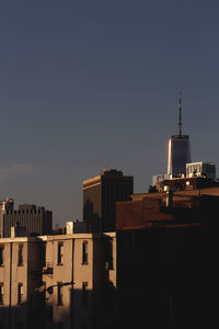 Low angle view of buildings against clear sky during sunset