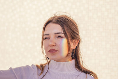 Portrait of a beautiful young woman against wall