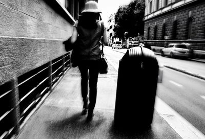 Man walking on footpath in city