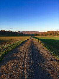 Empty road on field against clear sky