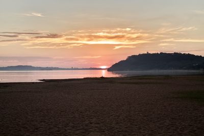 Scenic view of beach against sky during sunset