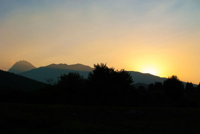 Scenic view of silhouette mountains against sky at sunset