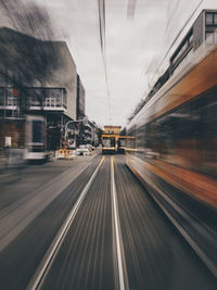 Blurred motion of train at railroad tracks in city