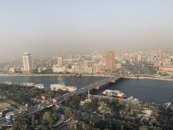 High angle view of river amidst buildings in city against sky