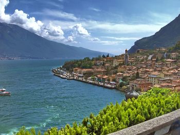 Aerial view of townscape by sea against sky