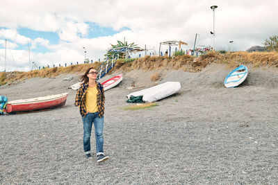 Woman in warm plaid shirt walking by sea on winter beach. traveling. wellbeing and harmony concept.