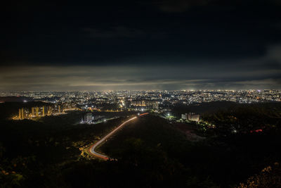 High angle view of illuminated city against sky at night