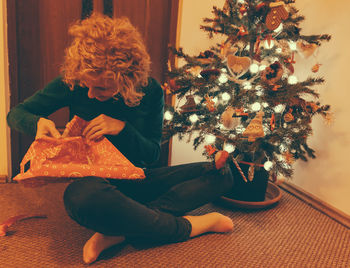 Portrait of woman unwrapping christmas gift