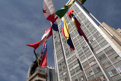 Low angle view of flags on building against sky