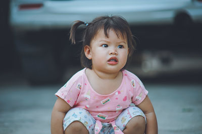Portrait of cute girl sitting outdoors