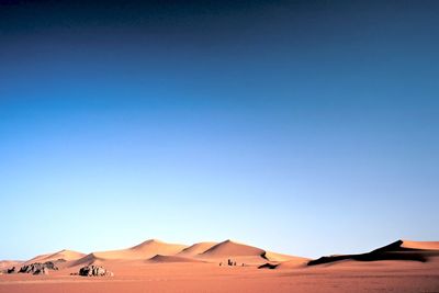 Scenic view of desert against clear blue sky