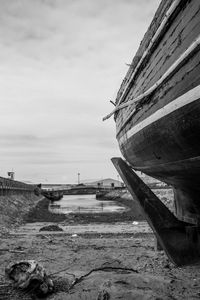 Boat moored on beach against sky