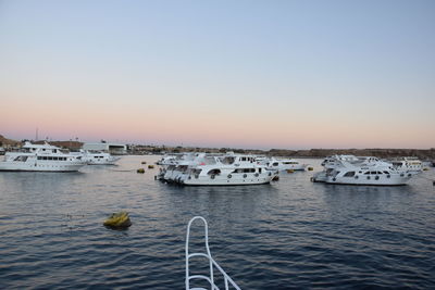 Boats in sea against clear sky