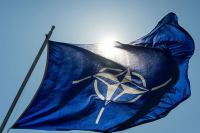 Low angle view of flag against blue sky