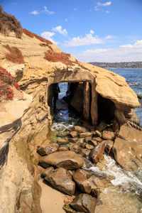 Rock formations by sea against sky