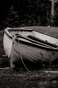 Side view of abandoned boats moored on field