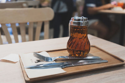 Close-up of honey with cutleries on wooden table