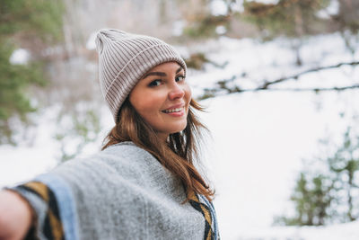 Portrait of smiling young woman in park during winter