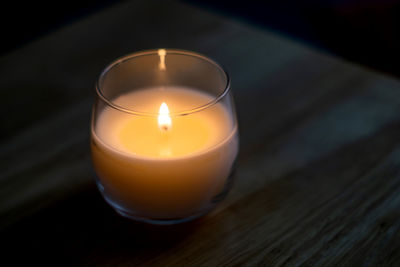 Close-up of illuminated tea light candle on table