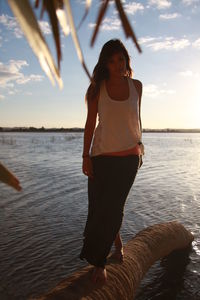 Full length of woman standing at sea shore against sky