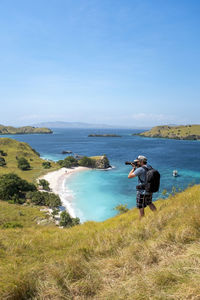 A photographer above pink beach in komodo national park, indonesia.