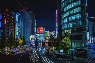 Light trails on city street by buildings at night