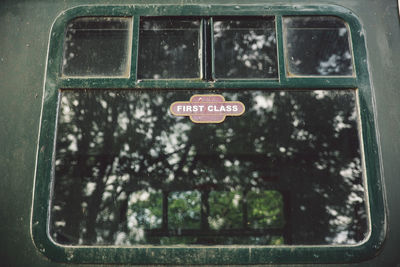 Low angle view of first class sign on window