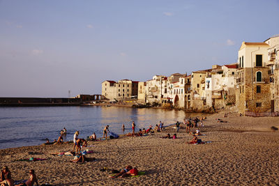 People on beach against clear sky