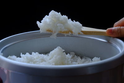 Close-up of hand holding ice cream in bowl