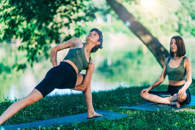 Yoga women by the water. twisted side angle