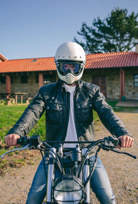 Portrait of man riding motorcycle on footpath