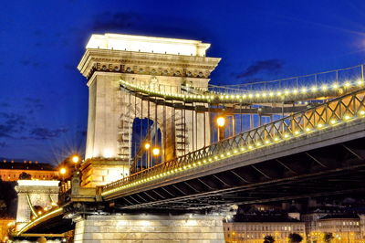 Low angle view of chain bridge against sky at dusk