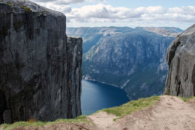 Scenic view of sea by mountains against sky