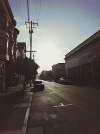 Cars on street in city against sky