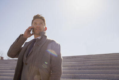 Portrait of a young businessman talking on his smartphone on a rooftop