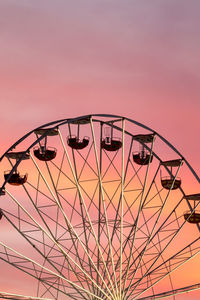 Low angle view of ferris wheel against sky during sunset