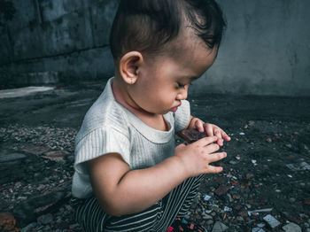 Cute boy looking away while standing against wall