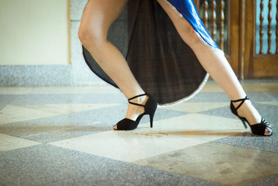 Low section of woman dancing on tiled floor