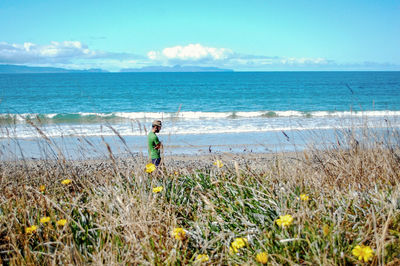 Man standing on beach against sky