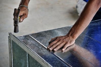 Cropped image of worker using hammer on metal