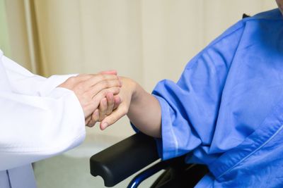 Close-up of doctor holding patient hand