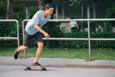 Man skateboarding on footpath