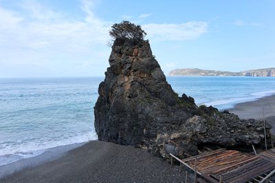 Scenic view of rocks on beach against sky