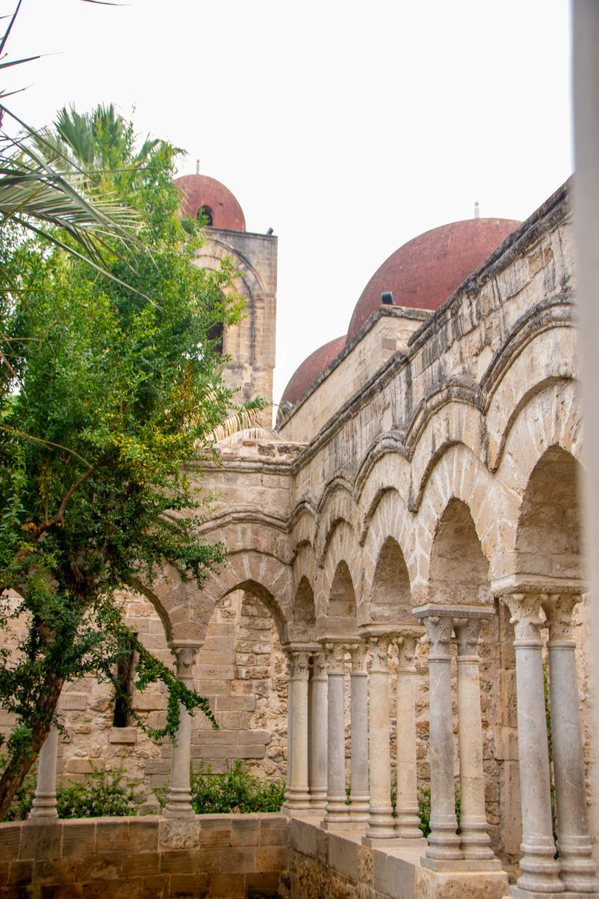 architecture, built structure, history, arch, building exterior, the past, travel destinations, tree, plant, nature, building, travel, tourism, religion, place of worship, courtyard, no people, sky, ancient history, architectural column, day, city, outdoors, ancient, palace, estate, clear sky, belief