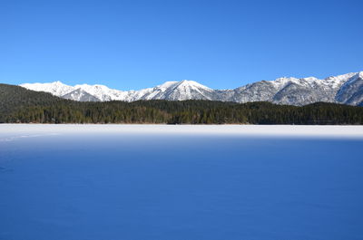 Scenic view of snowcapped mountains against clear blue sky