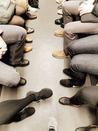 Low section of people sitting on floor
