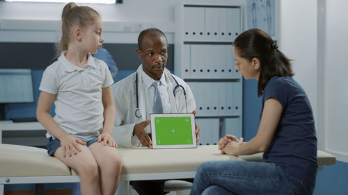 Doctor showing digital tablet to patient